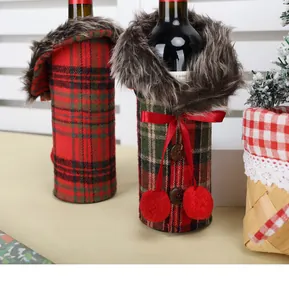 Macro detail of Christmas plaid wine bottle covers with red bows and faux fur collars.