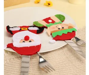 Vue détaillée de porte-couverts en feutre Père Noël et Elfe sur une assiette de fête