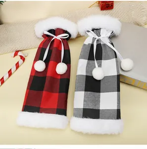 Pair of plush Christmas plaid wine bottle covers in red-black and white-black checks.