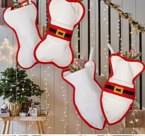 Detail view of white plush bone-shaped Christmas stockings with Santa belt accents