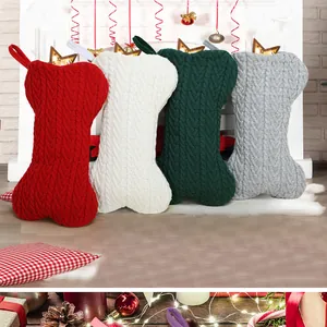 Gros plan de quatre chaussettes de Noël tricotées en forme d'os en rouge, blanc, vert et gris