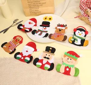 Vue détaillée de divers porte-couverts de Noël en dessin animé sur une table de fête.