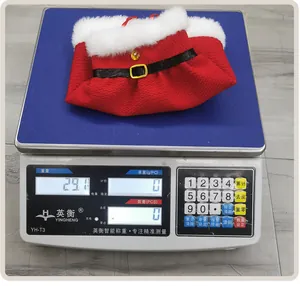 Detailed view showing a Christmas wine bottle cover being weighed at 29.1 grams
