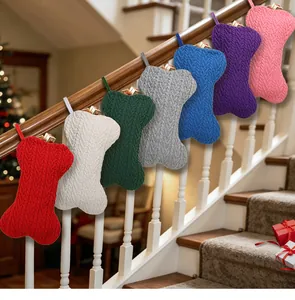 Chaussettes de Noël tricotées en forme d'os suspendues à une rampe d'escalier intérieure