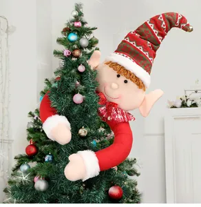 Vista ravvicinata di un grande elfo di Natale che abbraccia un albero decorativo.