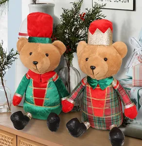 Pair of festive Christmas plush bears in soldier and crown outfits on a wooden mantle.