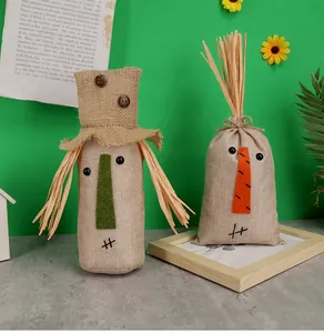 Close-up of rustic burlap Thanksgiving scarecrow dolls with straw accents and felt nose details