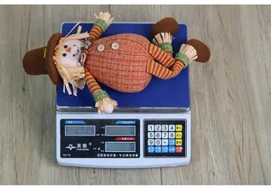Close-up detail of autumn harvest scarecrow doll being weighed on an electronic scale