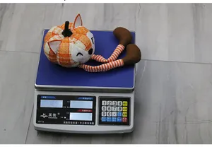 Gros plan de la peluche renard citrouille de Thanksgiving pesée sur une balance électronique