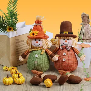 Pair of autumn harvest scarecrow dolls with sunflower accents for Thanksgiving decor.