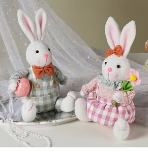 Coppia di graziose bambole di peluche a forma di coniglietto pasquale seduto per la casa