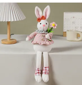 Gedetailleerd zicht op een schattige paashaas knuffelpop in een roze bloemenjurk op tafel