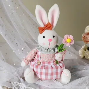 Dettaglio di un coniglietto di peluche seduto in abito a scacchi rosa per Pasqua.