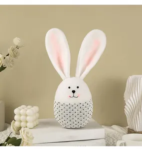 Gros plan détaillé d'une poupée de lapin de Pâques en peluche sur des livres blancs