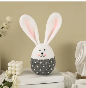 Vue détaillée d'un mignon œuf de lapin de Pâques en feutre avec un pull gris