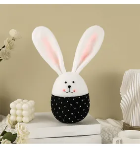 Détail d'un ornement d'oeuf de lapin de Pâques en peluche sur des livres blancs