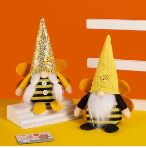 Close-up of two bumble bee gnomes with sequins and knitted hats for Bee Day decoration