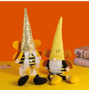 Detailed view of two bee-themed holiday gnomes with sequined and knitted hats