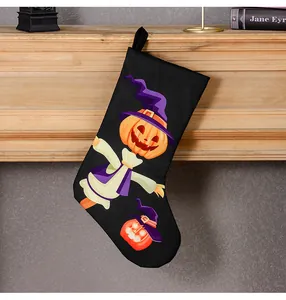 Calza decorativa nera per Halloween con stampa spaventapasseri zucca appesa a una mensola camino