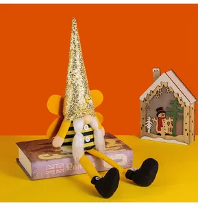Handmade bumblebee festival gnome plush with sequined hat sitting on book decor