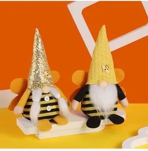 Macro view of handmade bee gnomes with striped bodies and sequined hats