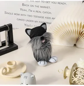 Detalle de un muñeco gnomo de peluche con gorro de gato negro y barba larga gris
