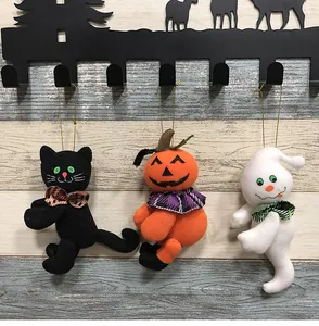 Nahaufnahme von Halloween-Plüschornamenten mit schwarzer Katze, Kürbis und Geist an Haken