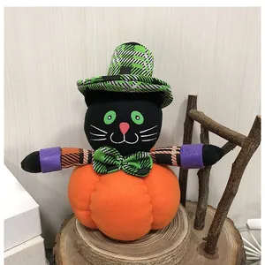 Detalle de un gato de peluche de Halloween en una calabaza con sombrero de cuadros
