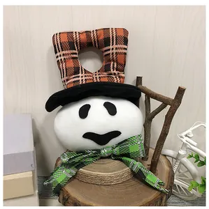 Detail of a plush ghost door hanger with orange plaid hat and green bow for Halloween.