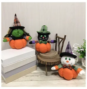 Tres lindos muñecos de calabaza de peluche de Halloween con bruja y gato en un cuarto