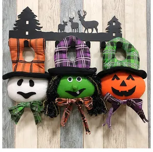 Detailed view of three plush Halloween door hangers: ghost, green witch, and pumpkin.