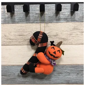 Detalle de un colgante de peluche de Halloween con una calabaza y un bastón de caramelo