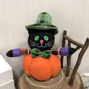 Muñeco de peluche de Halloween de gato negro sobre calabaza naranja adorno.