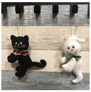Detaillierte Nahaufnahme von Halloween Plüsch Katze und Geist Dekorationen an Holzwand