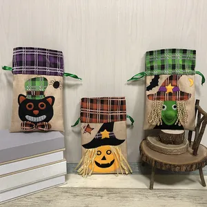 Tre sacchetti regalo di Halloween in juta con coulisse e motivi di zucca, strega e gatto.