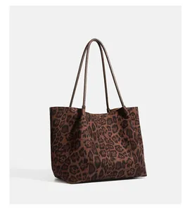 Side view of a vintage leopard print suede tote bag featuring long slim shoulder straps.