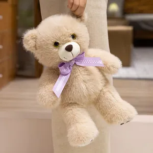 Schattige lichtbruine teddybeer knuffel met een paarse gestippelde strik als cadeau