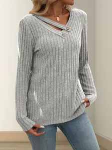 Detailansicht eines grauen Langarmshirts mit Rippenmuster und geknöpftem V-Ausschnitt.