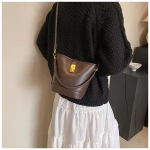 Vintage brown bucket bag shown from behind on a model wearing a black knit sweater