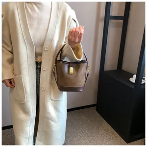 Stylish vintage brown minimalist bucket bag with gold buckle hardware and long shoulder strap