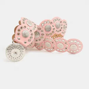 Detailansicht eines rosa Y2K-Gürtels im Boho-Stil mit Nieten und Metallverzierungen.