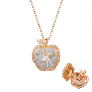 Roségouden appelmedaillon ketting met ballerina emaille en zwaan hanger detail.