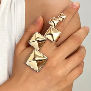 Detailed shot of punk style gold pyramid rings worn on hand for edgy fashion looks.