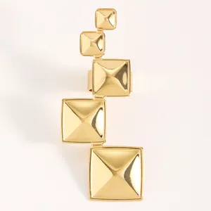 Vue détaillée d'une bague géométrique dorée avec des motifs de pyramides carrées