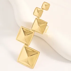 Détail de la boucle d'oreille géométrique en or avec pyramides carrées