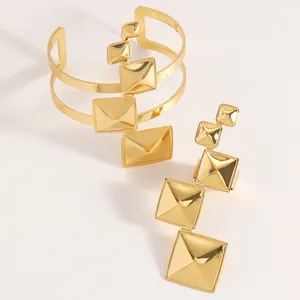 Detailed view of gold geometric pyramid jewelry set with cuff bracelet and long ring