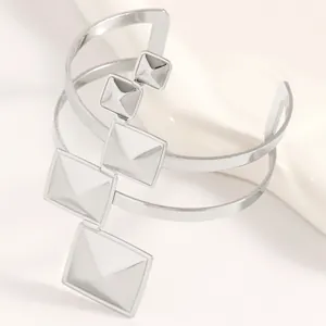 Vue détaillée d'un bracelet manchette argenté avec clous pyramidaux géométriques