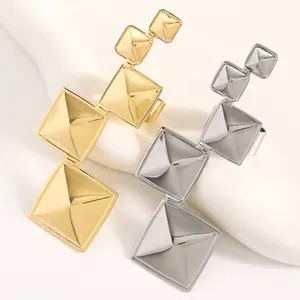 Détail de bagues géométriques en forme de pyramide, finitions dorées et argentées