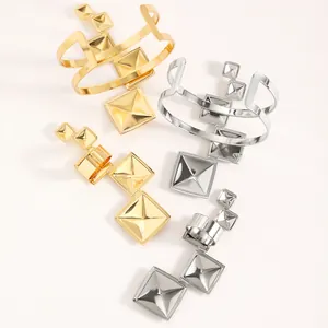 Detailed view of gold and silver pyramid studded bracelet and ring jewelry set collection