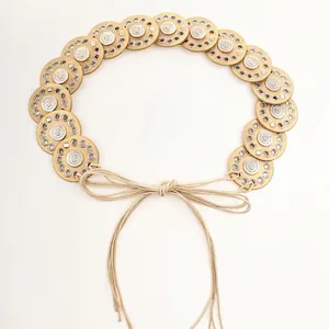 Detailed view of bohemian style belt featuring decorative golden disks and rope tie